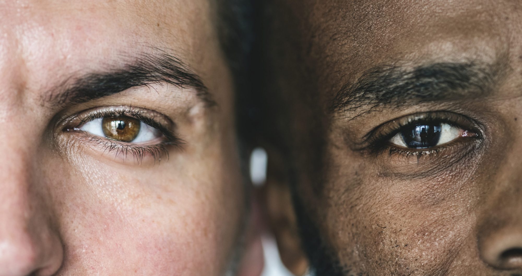 Two different ethnic men's eyes closeup